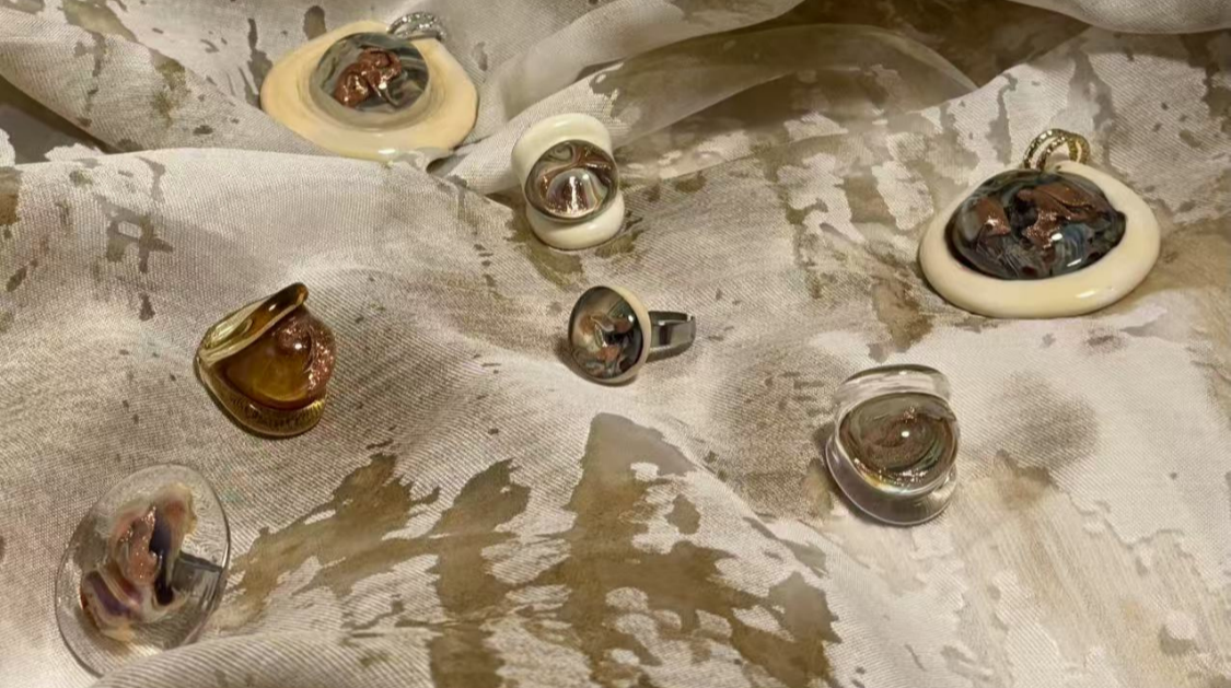 Jewelry set on a textured fabric background with 'Stella Fluente' branding.