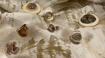 Jewelry set on a textured fabric background with 'Stella Fluente' branding.